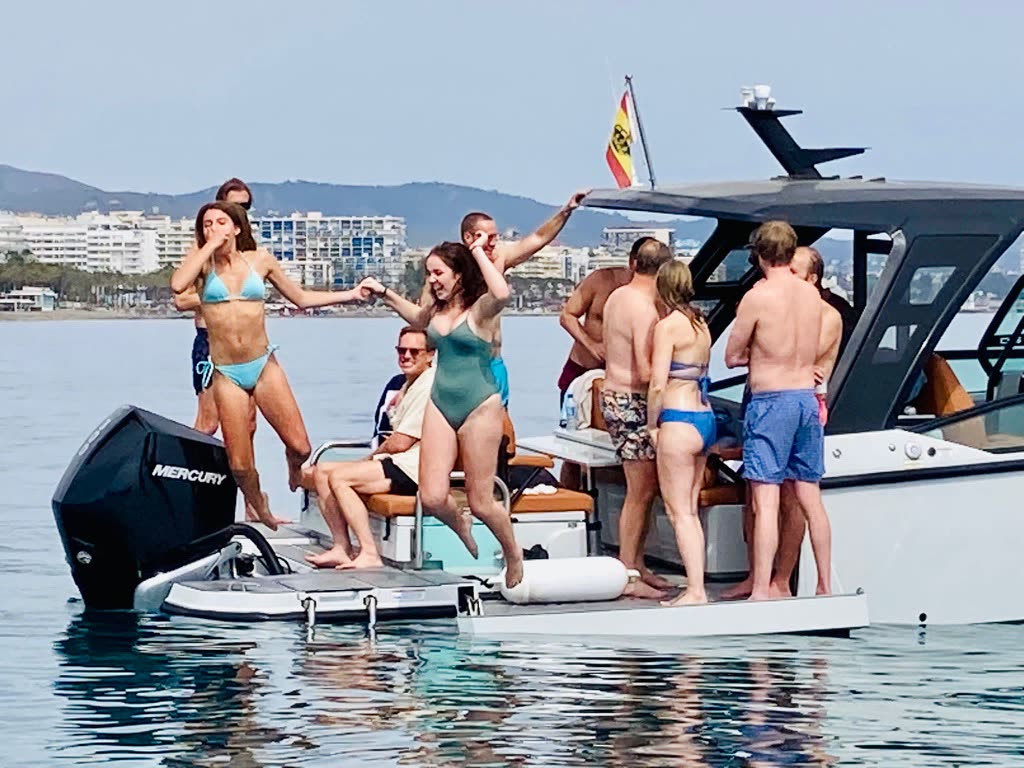 Friends dancing on the back of a boat off Marbella