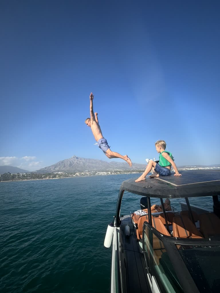 Martin diving off a boat with La Concha mountain behind, Marbella
