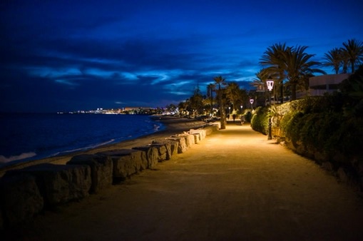 Lit coastal path along the beach at night outside Marbella