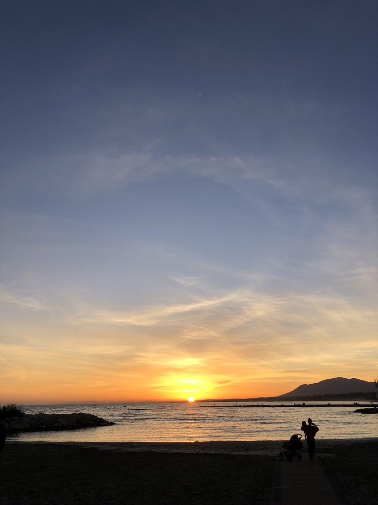 Father and child on the beach at sunset in Marbella