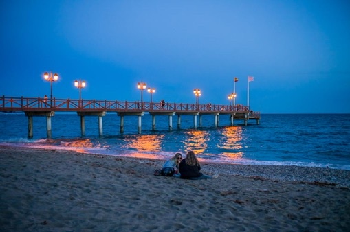 Wooden pier lit at blue hour on a Marbella beach